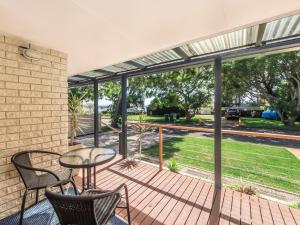 patio con tavolo e sedie su una terrazza di Narimba Motel a Port Macquarie