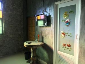 a bathroom with a sink and a tv on the wall at Farm stay 1000 Chang Valley in Ban Chak Phai