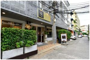ein Gebäude an einer Straße mit Pflanzen davor in der Unterkunft Ratchadamnoen Residence in Bangkok + 26 Fotos