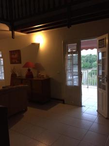una sala de estar con una puerta que da a un balcón en La Colombine, en Sainte-Anne