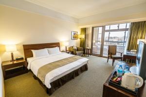 a hotel room with a bed and a large window at Fullon Hotel Jhongli in Zhongli