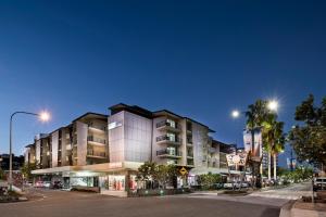 a building on a city street at night at Grand Hotel and Apartments Townsville in Townsville