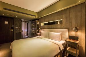台北的住宿－薆悅酒店，卧室配有一张白色大床和一张书桌