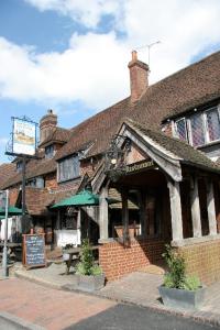 un vieux bâtiment avec un panneau devant lui dans l'établissement Chequers Inn Hotel, à Forest Row