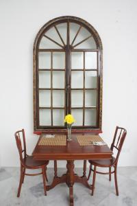 a table with two chairs and a window at Heeren Straits Hotel in Malacca