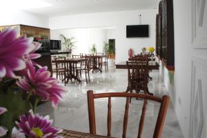 a dining room with tables and chairs and purple flowers at Heeren Straits Hotel in Malacca