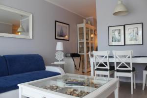 a living room with a blue couch and a table at Playa Baltis Exclusive Suites in Międzyzdroje