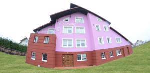 a large pink building on top of a hill at Noclegi"DOM RÓŻANY" Myszyniec in Myszyniec +5 photos