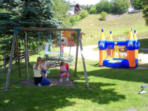 a woman and two children playing in a playground at Pension Hatzis in Laion