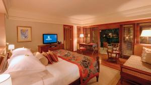 
a hotel room with two beds and a television at Constance Prince Maurice in Belle Mare
