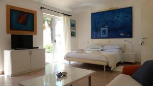 a bedroom with a bed and a tv and a couch at Corte dei merli Apartment & Studio in Rovinj
