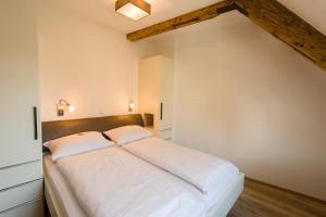 a large bed in a room with white walls at Hotel Garni Viktoria in Lindau