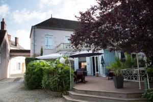 a house with umbrellas and a table and chairs at Blanche de Castille in Bléneau