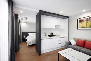 a living room with a couch and a bed at Arban City Hotel in Busan