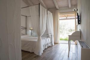 1 dormitorio con cama con dosel y ventana en Nacchinono, en Olbia