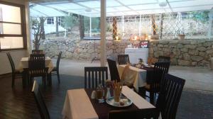 a restaurant with tables and chairs and a stone wall at Resort Village T.N. Milna in Vis