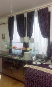 a buffet in a room with purple curtains at Resort Village T.N. Milna in Vis