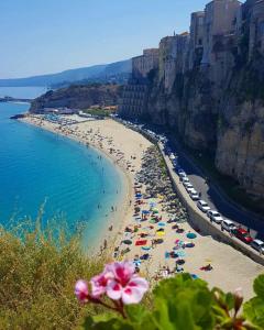 a beach with umbrellas and people in the water at Il Cremino in Tropea