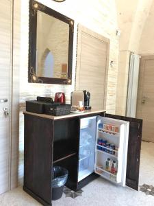 a black counter with a refrigerator and a mirror at Il Casolare Degli Ulivi in Oria