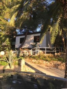 a white house with a fence in front of it at Resort Village T.N. Milna in Vis