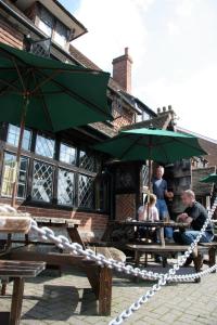 a group of people sitting at picnic tables with umbrellas at Chequers Inn Hotel in Forest Row