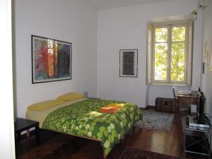 a bedroom with a bed with a green comforter at Al Porta Susa B&B in Turin