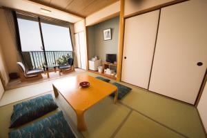 sala de estar con mesa, sofá y ventana en Senjoen, en Shimokō