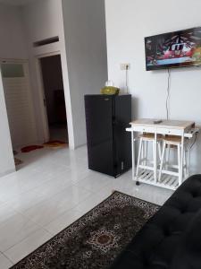 uma sala de estar com um frigorífico preto e uma mesa em Villa Puncak Garuda A5 em Batu