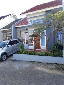 une voiture garée devant une maison dans l'établissement Villa Puncak Garuda A5, à Batu
