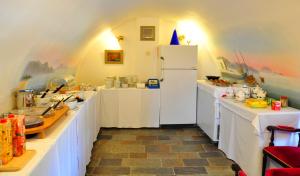 a kitchen with white counters and a white refrigerator at Margarita Hotel in Kythira