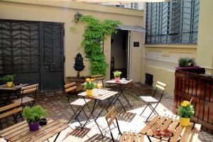 Un patio con mesas y sillas y plantas. en Gabriele 83, en Turín