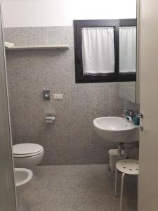 a bathroom with a toilet and a sink at Lacroma Bio Hotel & Apartments in Grado