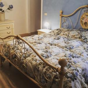 a bedroom with a bed with a floral blanket at B&B Aria Dell’' Etna in Zafferana Etnea