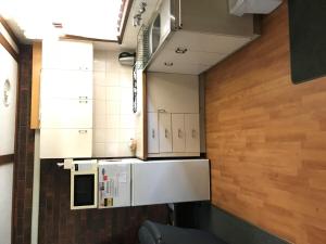 a small kitchen with white cabinets and a refrigerator at Kalamunda 2 in Bright