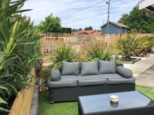 een bank in een tuin met een tafel bij La ravissante ferretcapienne in Lège-Cap-Ferret