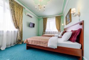 Schlafzimmer mit einem Bett und einem Kronleuchter in der Unterkunft Well House Hotel in Wolgograd