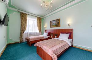 a hotel room with two beds and a chandelier at Well House Hotel in Volgograd