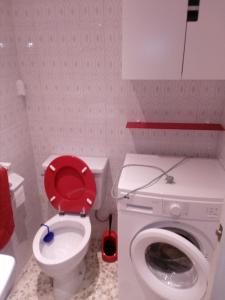 トレモリノスにあるVistas al Marのバスルーム(赤い蓋付きトイレ、洗濯機付)