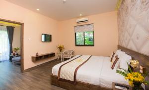 朱篤的住宿－Sang Như Ngọc Resort，一间卧室配有一张床、一张书桌和一个窗户。