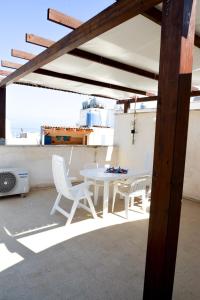 einen weißen Tisch und Stühle auf einer Terrasse in der Unterkunft Casa Duran in Marettimo