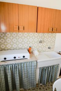 una cocina con fregadero blanco y armarios de madera en Casa Duran, en Marettimo