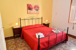 a bedroom with a red bed with two stuffed animals on it at Casa Duran in Marettimo