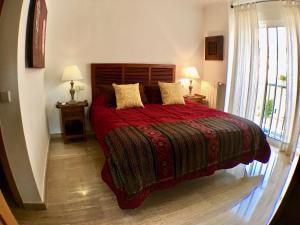 アルビールにあるResidencia La Mina - Albirのベッドルーム1室(赤いベッド1台、ランプ2つ、窓付)
