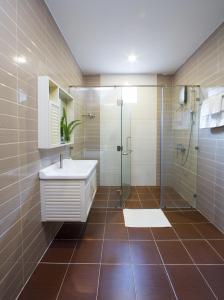y baño con lavabo y ducha acristalada. en Sang Như Ngọc Resort en Chau Doc