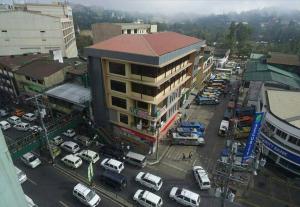 uma vista superior de uma cidade com carros estacionados num parque de estacionamento em A Hotel Baguio em Baguio