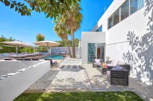 a white house with a pool and patio furniture at Casa India Ibiza in Santa Eularia des Riu