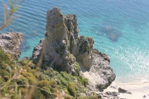 a large rock formation next to the ocean at A Turri in Capo Vaticano