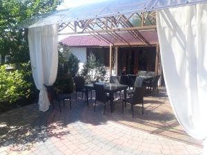 patio con tavolo e sedie sotto un baldacchino di Ametist a Mukačevo