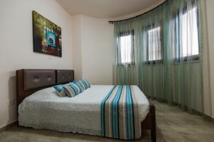 1 dormitorio con 1 cama y 2 ventanas en Luxury Villa Regina, en Protaras