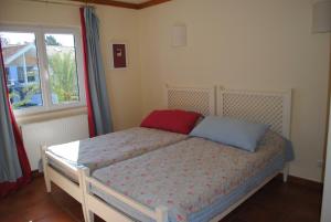 1 dormitorio con 1 cama con almohada roja y azul en Aldeamento Turistico Casas da Comporta en Comporta